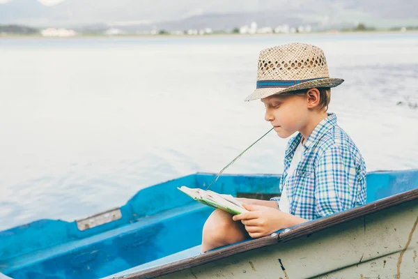 Çocuk Göl Kıyısındaki Eski Teknede Kitap Okuyor — Stok fotoğraf