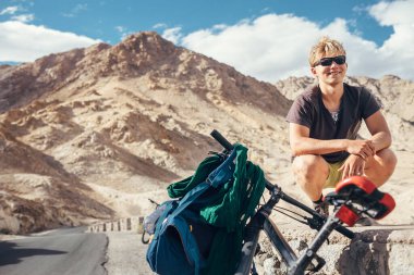 Genç turist Himalaya Montain 'de bisikletle seyahat ediyor.