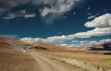 Dağ manzarası ve yolda yalnız bir araba.