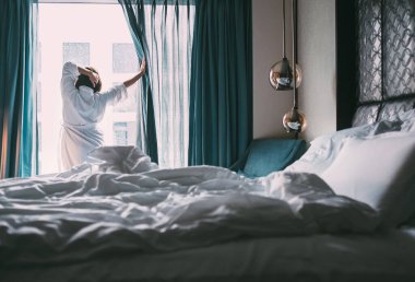 Kadın yağmurlu sabahla lüks otel odasında buluşuyor.
