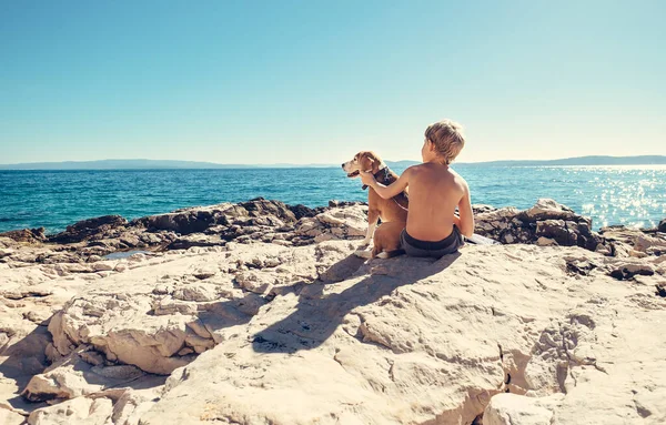 Jongen Met Beagle Hond Zitten Samen Rotsachtige Kust Zonnige Middag — Stockfoto