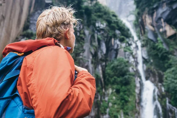 Turist Med Ryggsäck Blickar Skog Vattenfall Regniga Berg — Stockfoto