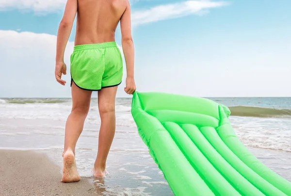 Jongen Met Groene Zwemmatras Staat Aan Zee — Stockfoto