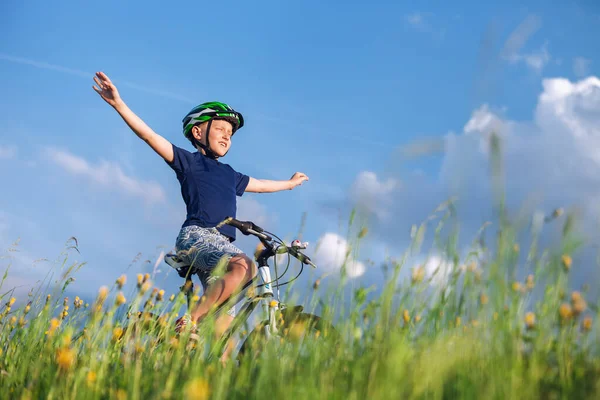 幸せな少年は手のない自転車に乗り 日光浴を楽しむ ストックフォト
