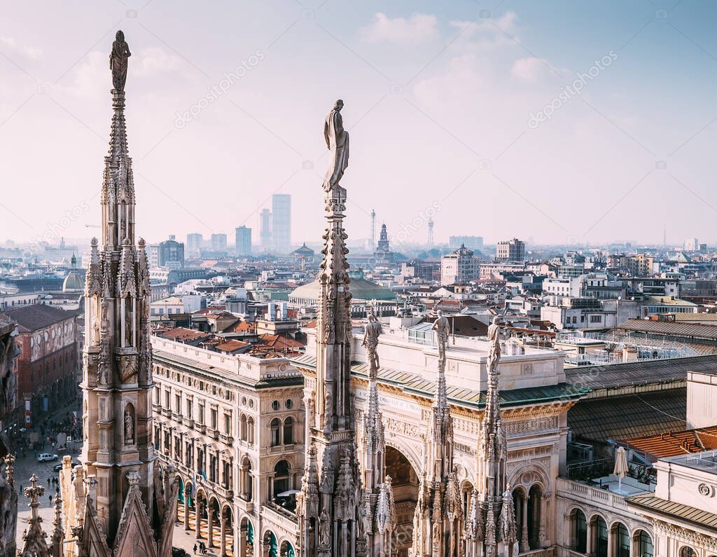 Numerous statues on steeples Duomo di Milano watches on city life