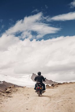 Lonely motocyclist traveler on mountain rosad in Himalaya clipart