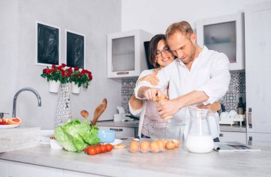 Mutfaktaki çift: kocası omlet pişiriyor.