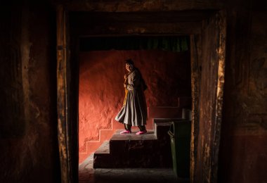 Ladakh, Hindistan 'daki Thikse Manastırı - 20 Ağustos 2016' da Hindistan 'ın Ladakh kentindeki Thiksey köyünde Tibetli keşiş kadın merdivenlerden iniyor