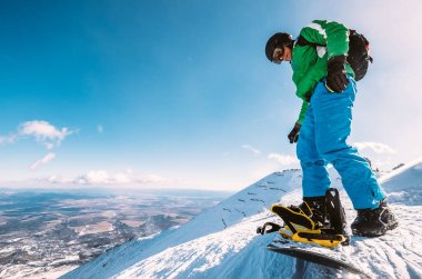 Snowboardcu kar tepesinden kaymaya hazır ol.