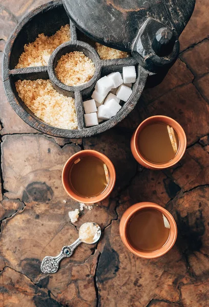 木のテーブルの上には生姜茶と素朴な砂糖丼が3杯 — ストック写真