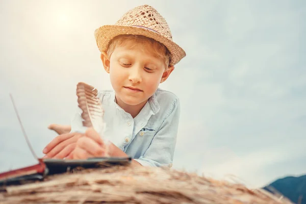 男の子は干し草のロールに横たわっている本を読む — ストック写真