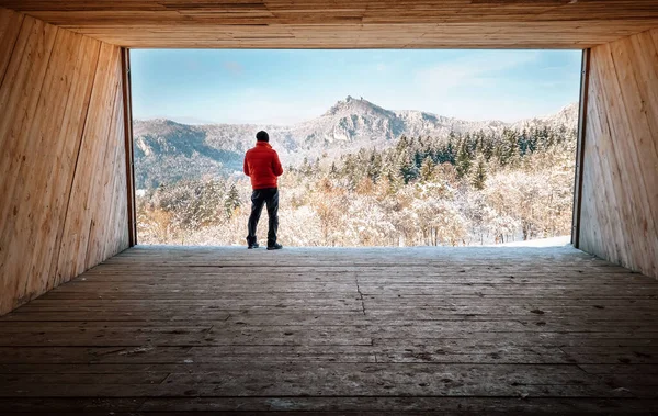Человек Остается Большом Деревянном Ангаре Смотрит Снежные Горы — стоковое фото