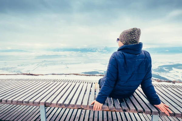 女人在山顶上休息 欣赏美丽的冬城全景 — 图库照片