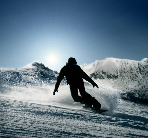 Snowboarder Glijdt Van Besneeuwde Heuvel — Stockfoto