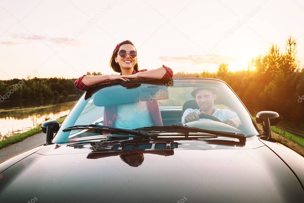 Traveling by car - couplr in love dgo by cabriolet car in sunset time