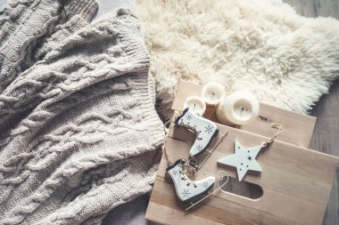 Büyük örülü süveter, mumlar ve Noel süslemeleri rahat bir yaşam tarzı.