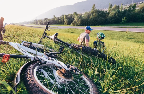 Padre Hijo Relajarse Hierba Verde Aftwr Paseo Bicicleta —  Fotos de Stock