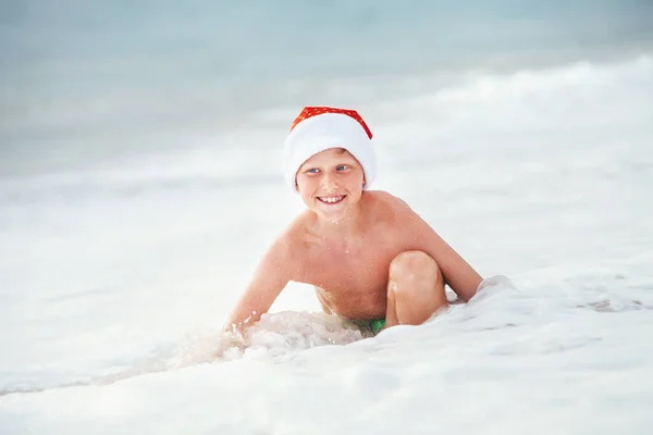 Gelukkige Jongen Santa Hoed Zwemt Oceaan Surflijn Kerstmis Nieuwjaarsvakantie Tropische — Stockfoto