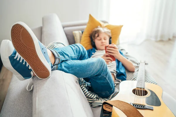 Tonårspojken Ligger Med Gitarr Mysiga Soffklädda Casual Jeans Och Nya — Stockfoto