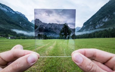 ND Gradyan Filtresi bardağı tutan profesyonel fotoğrafçı bir efekti takdir ediyor. Logar Vadisi, Slovenya.