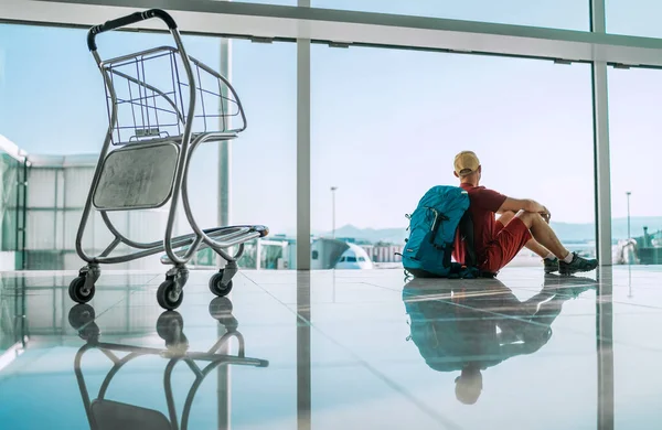 Alone Backpacker Traveller Sitting Airport Terminal Floor Empty Airport Trolley — Stock Photo, Image