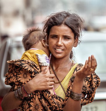 Yeni Delhi, Hindistan - 14 Ağustos 2016: Yeni Delhi, Hindistan 'da bebeği olan genç Hintli dilenci kadın sadaka dileniyor