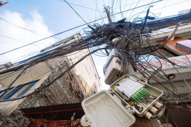 Muazzam miktarda elektrik kablosu, telefon iletişimi sokak direklerine bağlı. Modern teknoloji, iletişim ve seyahat kavramı.