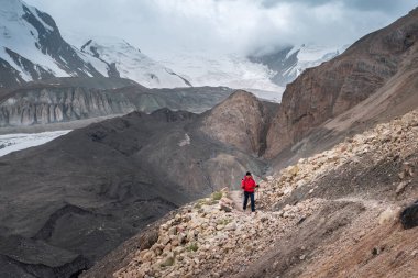 Sırt çantası ve yürüyüş direkleri olan yalnız dağcı kadın Lenin zirvesine çıkarken arka planda dağ zirveleri ve buzullar vardı. Aşırı aktif insanlar, yüksek rakımlı dağcılık konsepti fotoğrafı