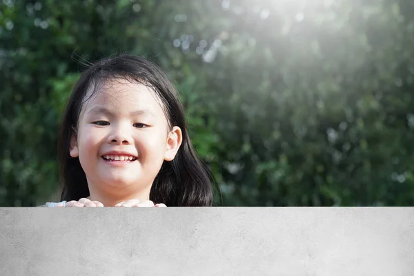 Portrait Happy Asian Young Girl Peeking Cement Fence Smile Beauty — стоковое фото