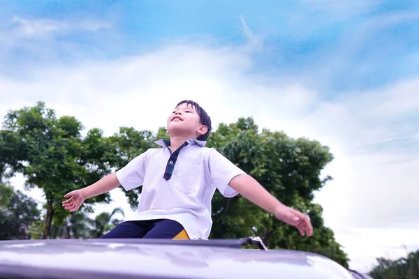 Забавный Азиатский Мальчик Стоящий Крыше Автомобиля Облаком Деревом Голубым Небом — стоковое фото