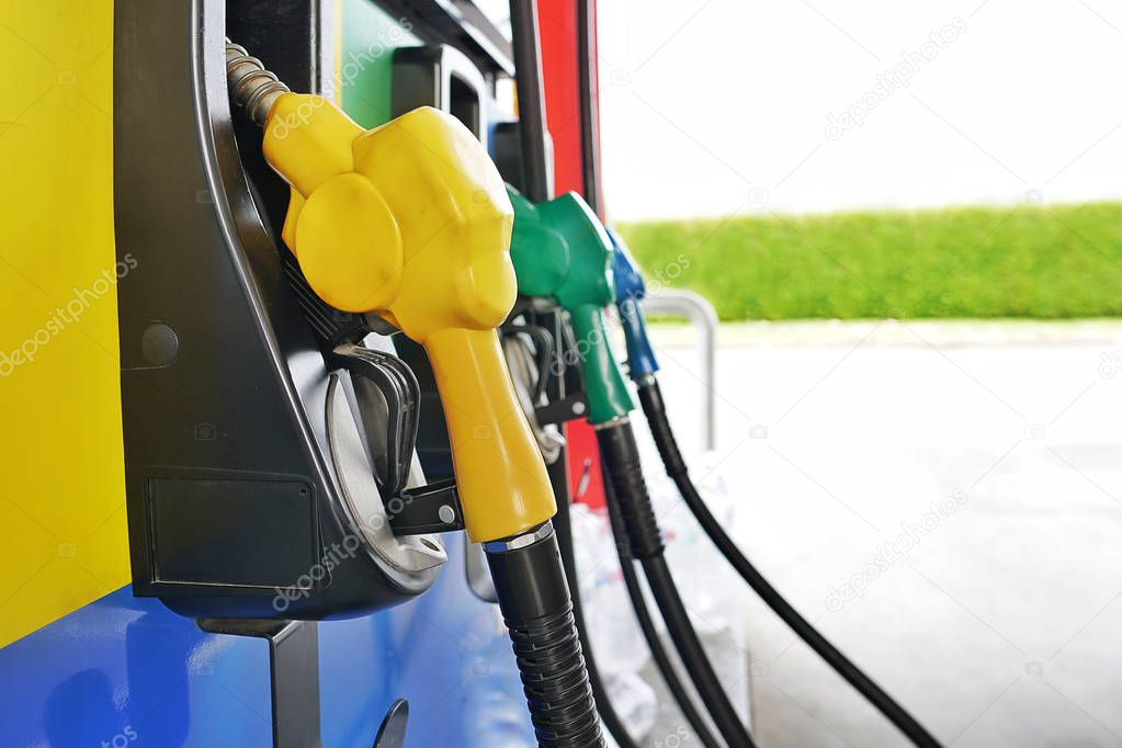  Colorful Petrol pump filling nozzle with pumping gasoline fuel at gas station service.The machine of refuel in gas pump.                              