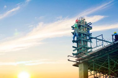 Mühendis iş kavramı inşaat sektöründe ayakta ve yüksek zemin ve çelik çubuk binadan güzel mavi gökyüzü ve bulutlar arka plan üzerinde inşaat sahasında çalışan işçi ile.