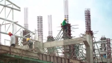 Mühendis iş kavramı inşaat sektöründe ayakta ve yüksek zemin ve çelik çubuk binadan vinç ile mavi gökyüzü ve bulutlar arka plan üzerinde inşaat sahasında çalışan işçi ile.