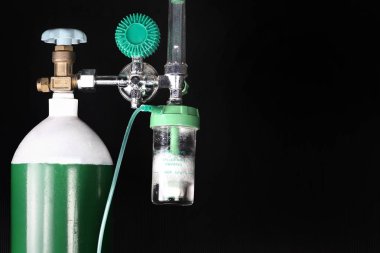 Ekipman tıbbi oksijen tankı ve silindir regülatör ölçmek. Bir hasta solunum hastalıkları ve Hastanesi Acil ilk yardım-oksijen gazı bakım için basınç kontrol yakın koyu arka plan üzerinde odak.        