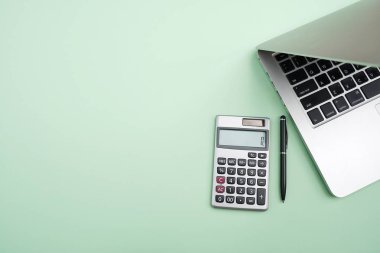Düz yatıyordu, en iyi görünümü office tablo resepsiyon. Hesap makinesi, siyah kalem, Indigo yeşil arka plan üstünde laptop ile çalışma alanı. Alan metin, boş boş Word'e kopyalayın. İş finans, eğitim teknolojisi kavramı.