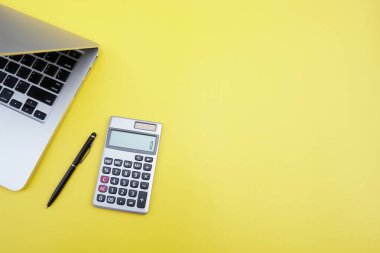 Düz yatıyordu, en iyi görünümü office tablo resepsiyon. Hesap makinesi, siyah kalem, sarı arka plan üstünde laptop ile çalışma alanı. Alan metin, boş boş Word'e kopyalayın. İş finans, eğitim teknolojisi kavramı
