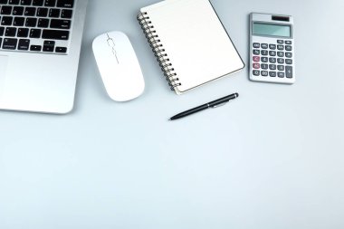 Üst görünüm ofis masa masası. Fare, defter, kalem ve hesap makineli dizüstü bilgisayarlı ofis aksesuarları içeren çalışma alanı. Boş sayfayı metin için kopyala. Düz sayfa 