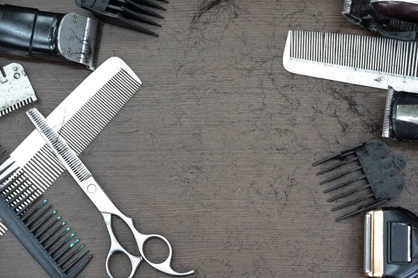 Set of cutting tools for cutting hair at barbershop beard salon.Hair accessories such as Clippers and Comb on wooden desk table in a professional hairdresser barber.Copy space empty blank for text.