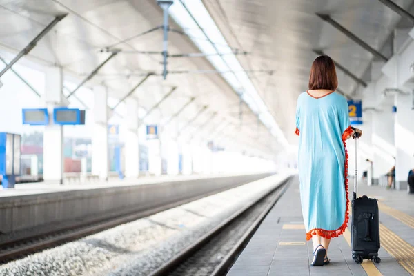 Traveler women on platform with luggage and belongings in the railway train station.Passenger waiting for train and going to journey.Enjoying travel.Vacation,Holiday,Transportation,Lifestyle Concept.