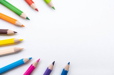 Beyaz kağıda izole edilmiş renkli kalemlerin ya da renkli kalemlerin üst görünümü. Okula geri dön..