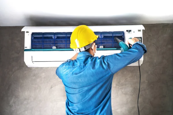 Technicien Réparateur Nettoyage Entretien Climatiseur Mural Avec Ventilateur Dans Chambre Images De Stock Libres De Droits