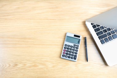 Evdeki ahşap masa çalışma odası dizüstü bilgisayarlı defter, tavan arası çimento arka planı hesap makinesi. Mesaj için boşluk kopyala. İş finansmanı, eğitim teknolojisi. Evden çalışma..