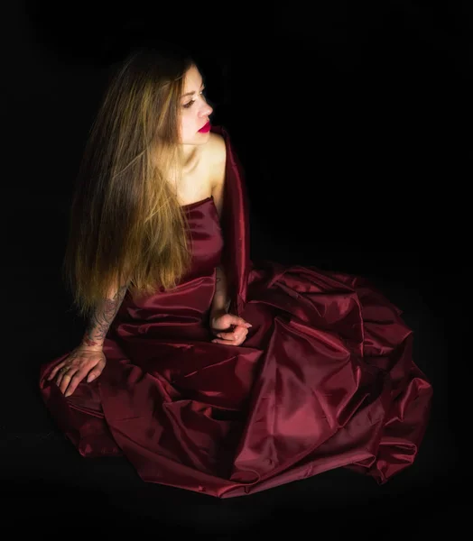 Posiert Tätowiertes Mädchen Unter Roter Decke Und Schwarzem Hintergrund — Stockfoto