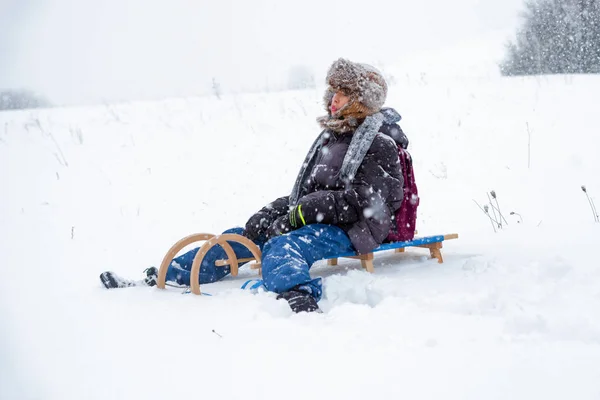 Chłopiec Siedzi Sankach Kraju Snowy — Zdjęcie stockowe