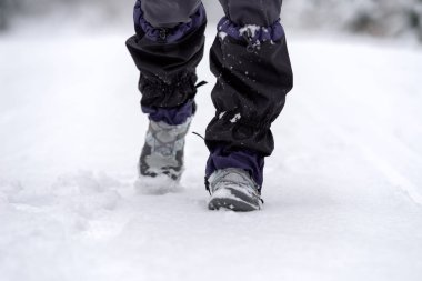 Hiker wearing a snow boots and gaiter at snowy winter country clipart