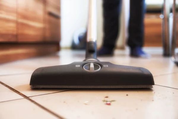 Persoon met behulp van stofzuiger tijdens het schoonmaken van de vloer van het vuil — Stockfoto