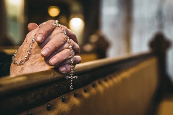 Orar mãos com rosário na igreja — Fotografia de Stock