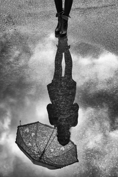 Reflection of girl with umbrella in water Royalty Free Stock Photos