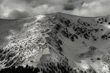 Gökyüzünde karlı tepeler ve bulutlar