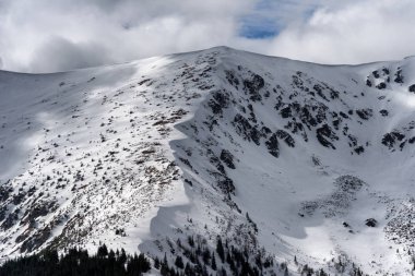 Gökyüzünde karlı tepeler ve bulutlar
